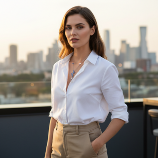 Woman in a white shirt and beige pants standing on a rooftop with a city skyline in the background