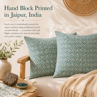 Two decorative throw pillows with a teal and off-white floral block-print pattern are styled on a cream sofa with a beige knit blanket. Text on the left reads 'Hand Block Printed in Jaipur, India' with descriptive copy about traditional craftsmanship.