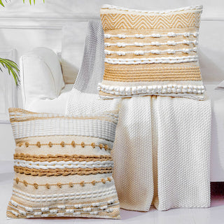 Textured pillows and blanket on a bed with a white background