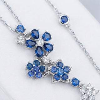 Silver necklace with blue gemstone pendants on a white background